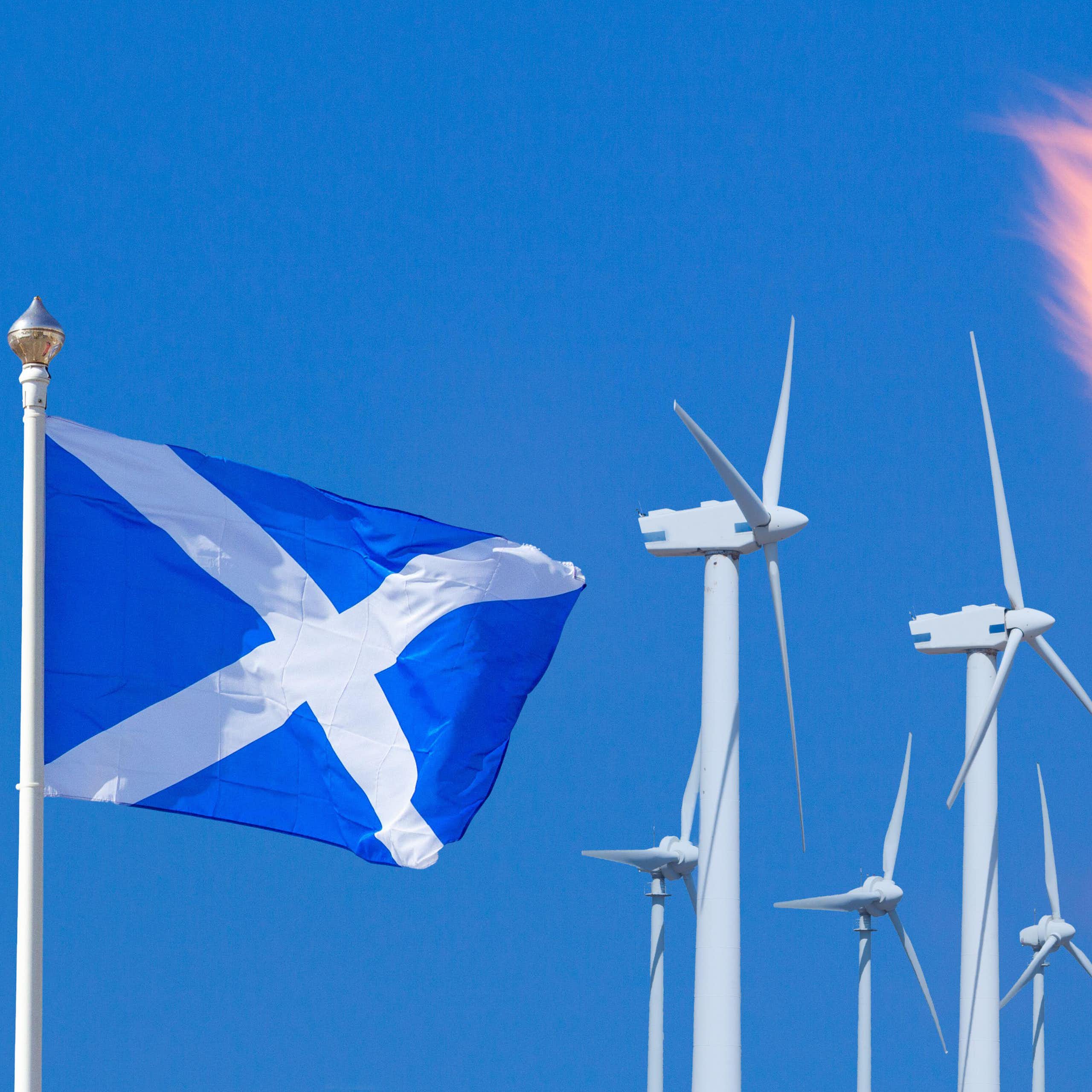 A Scottish flag next to wind turbines and a gas flare.
