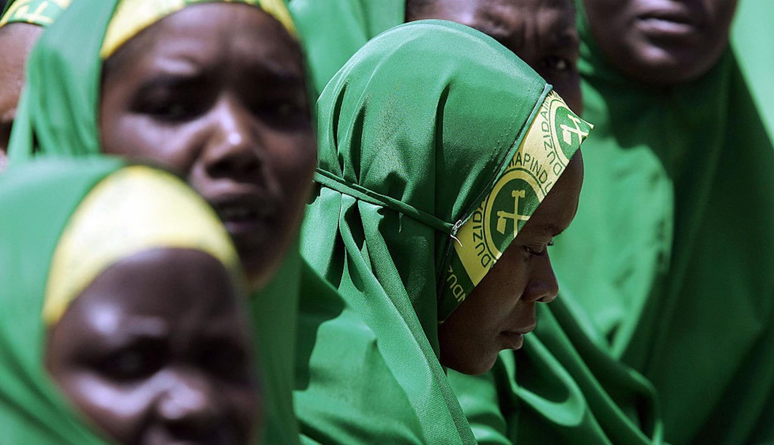 A close-up of women veiled in green and yellow