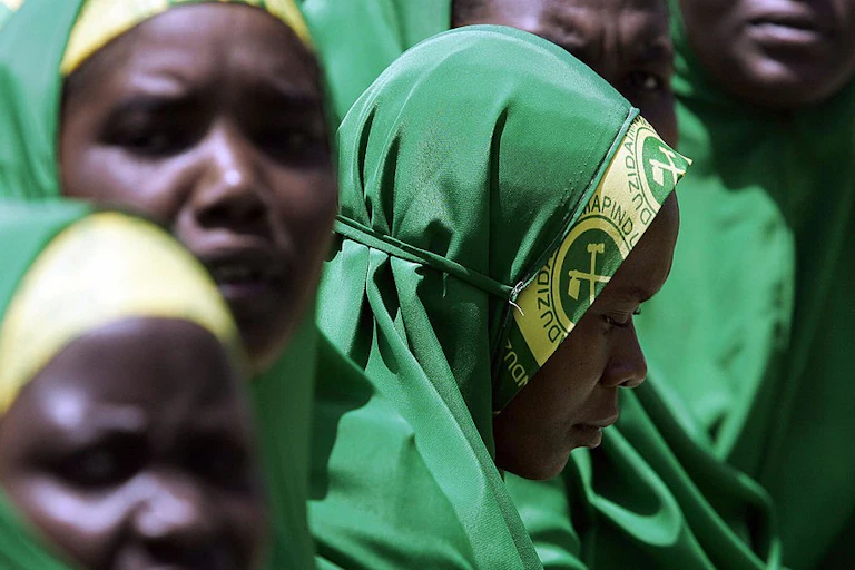 A close-up of women veiled in green and yellow