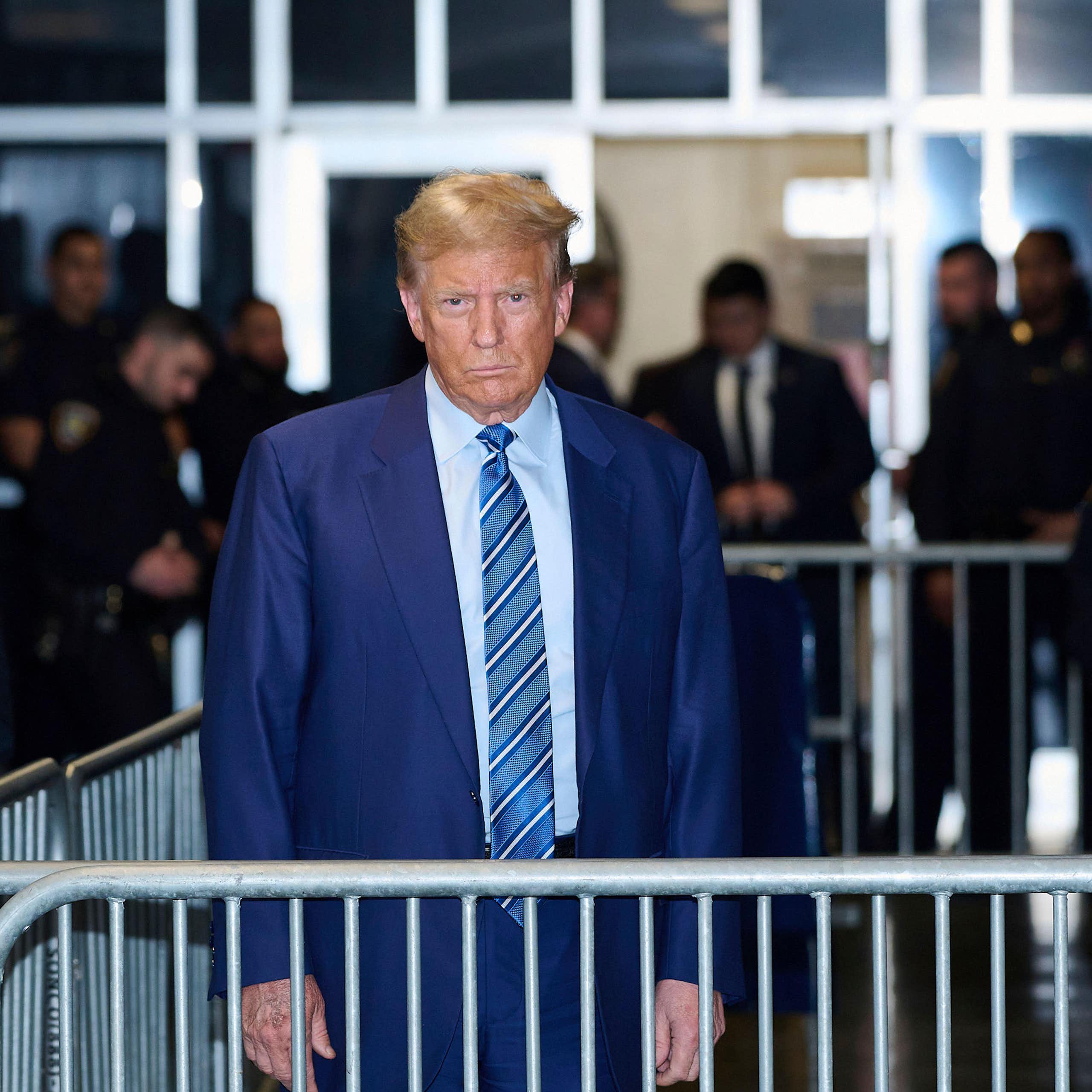 Donald Trump in a blue suit near to a court.