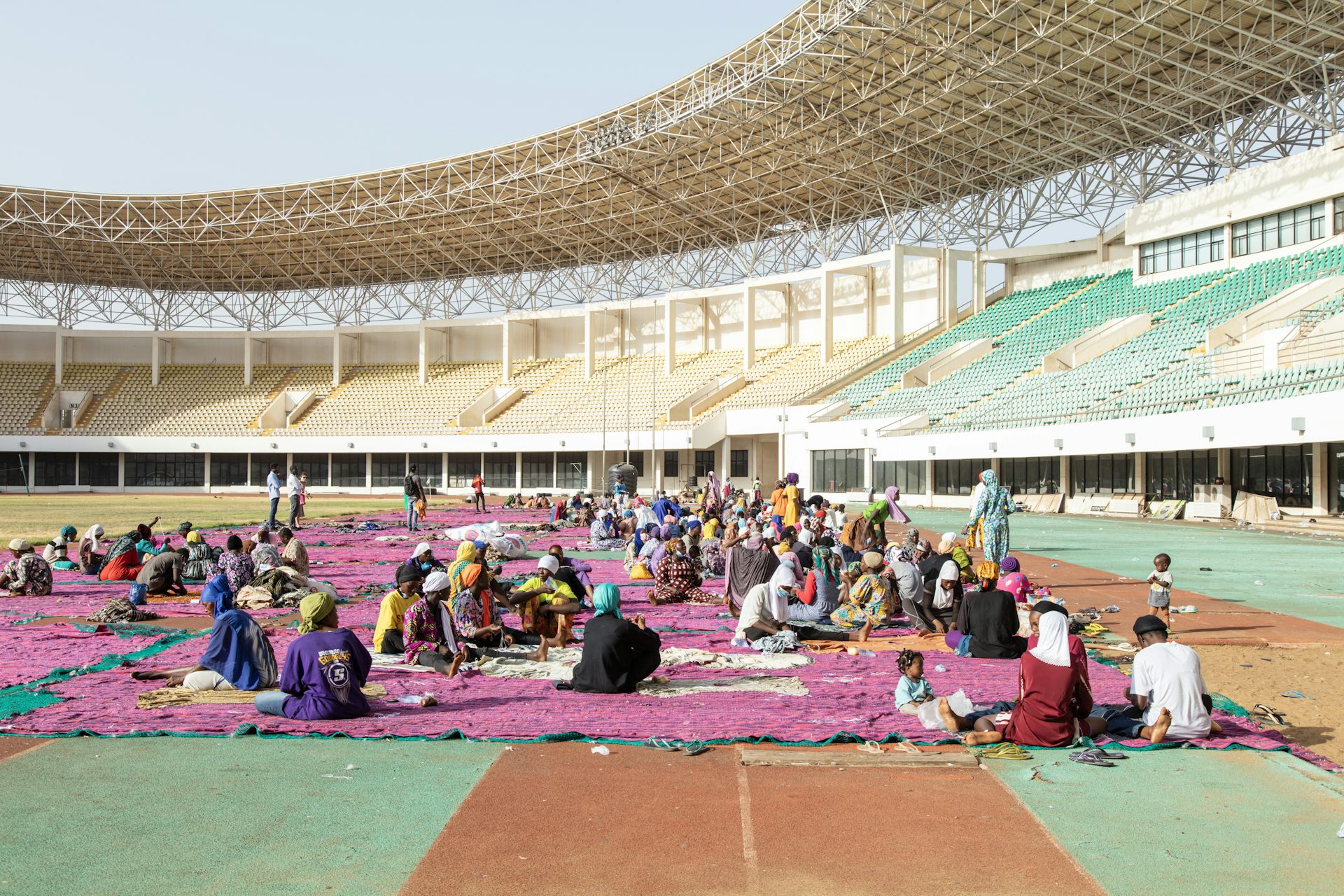 People working on purple fabric in a football stadium