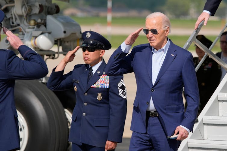 Joe Biden salutes after disembarking from Air Force One at Andrew Air Base.