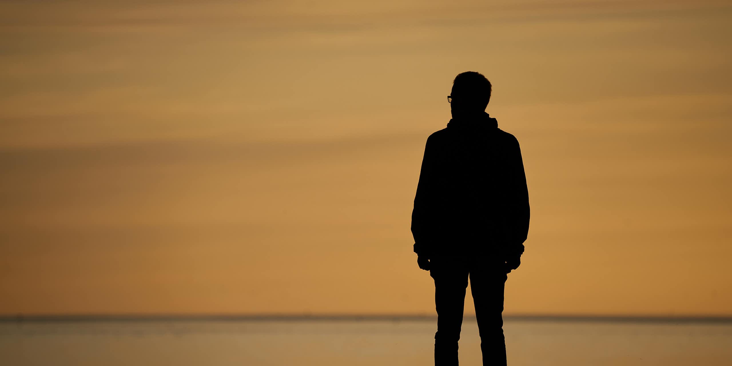 A man standing alone on a sea front