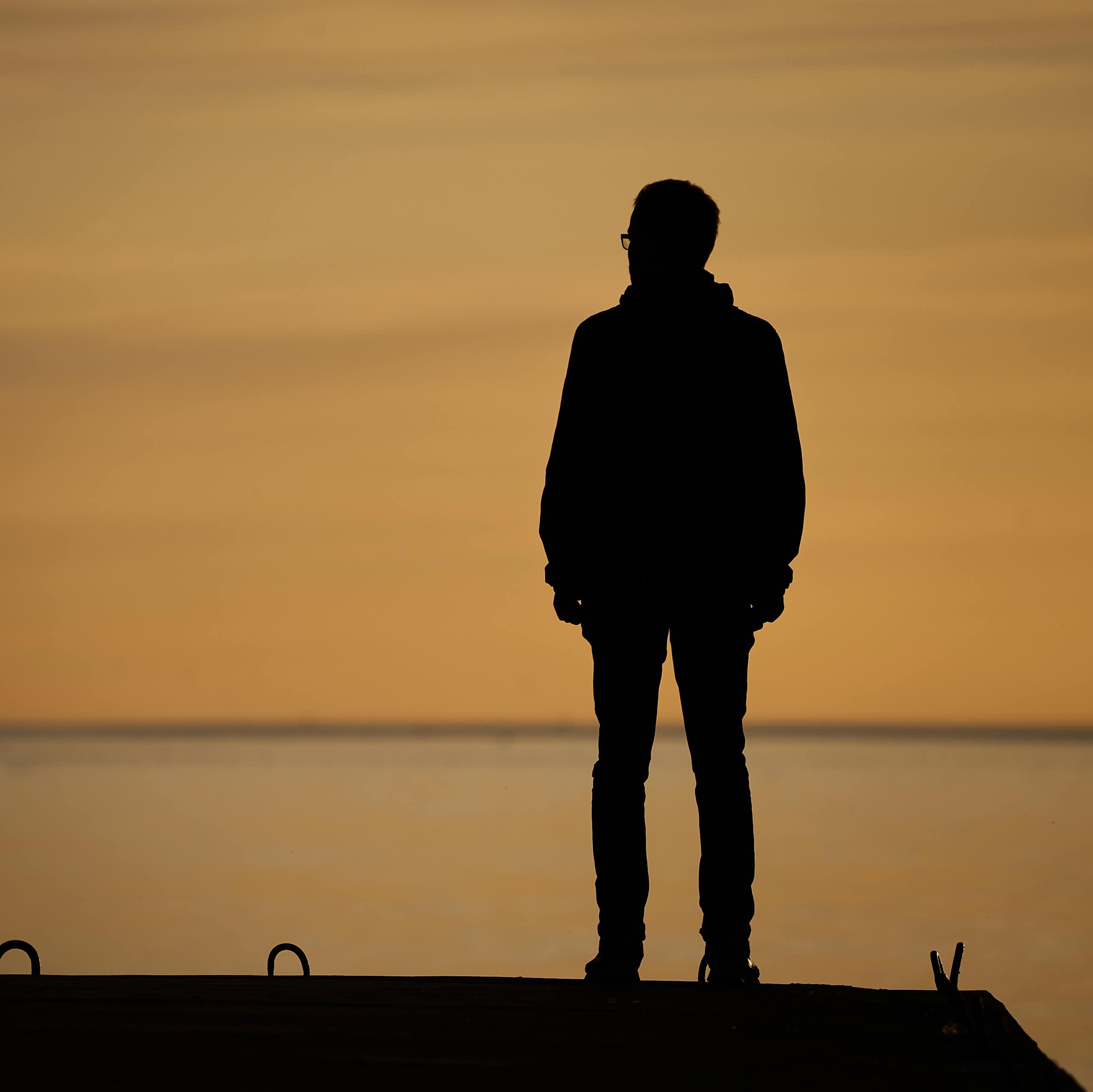 A man standing alone on a sea front