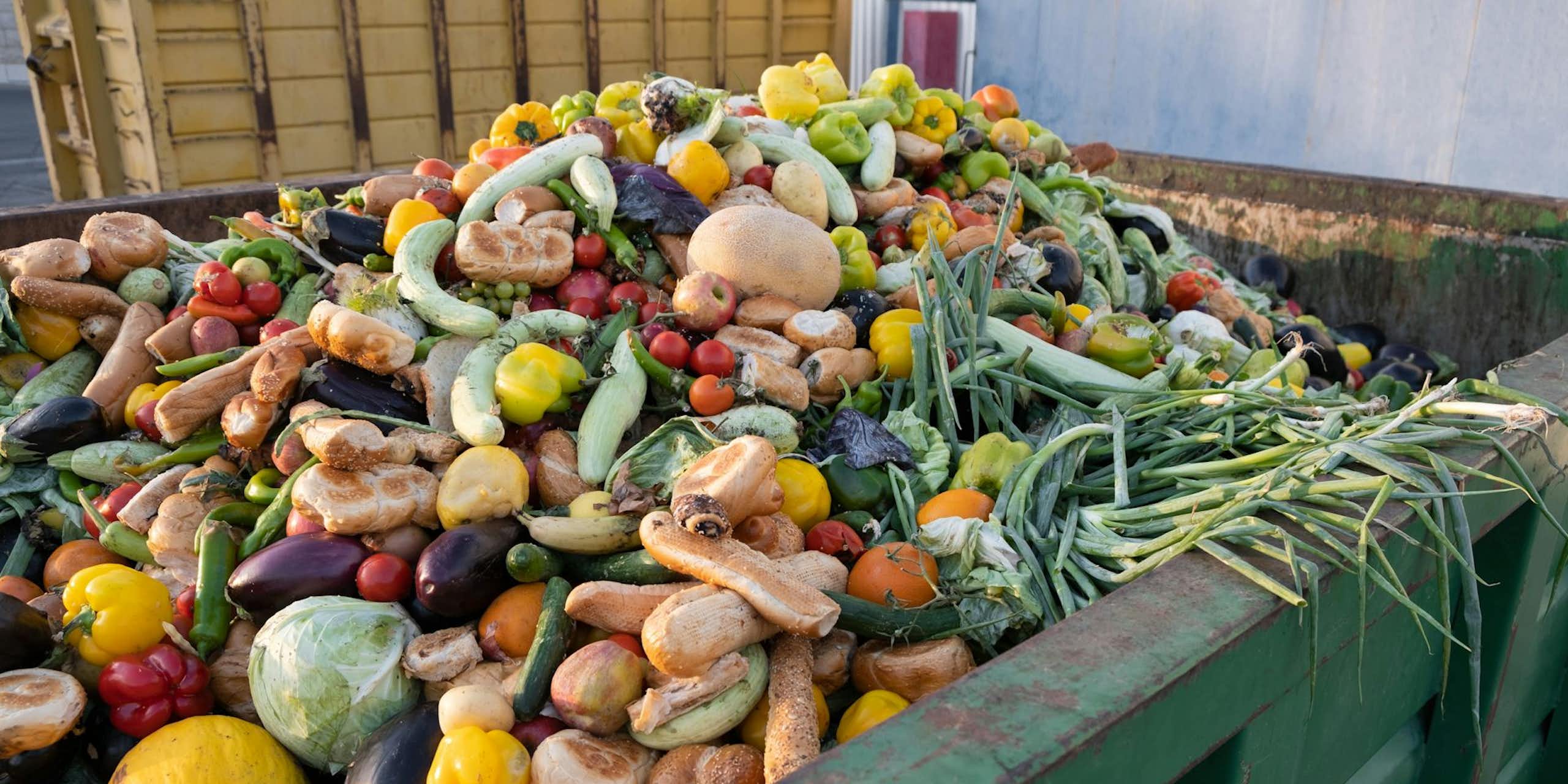 Vegetables piled in a garbage bin.