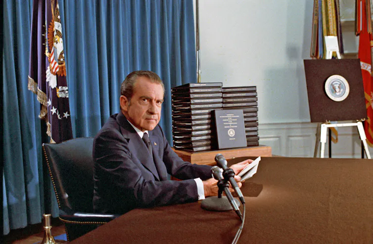 Richard Nixon sitting behind a desk