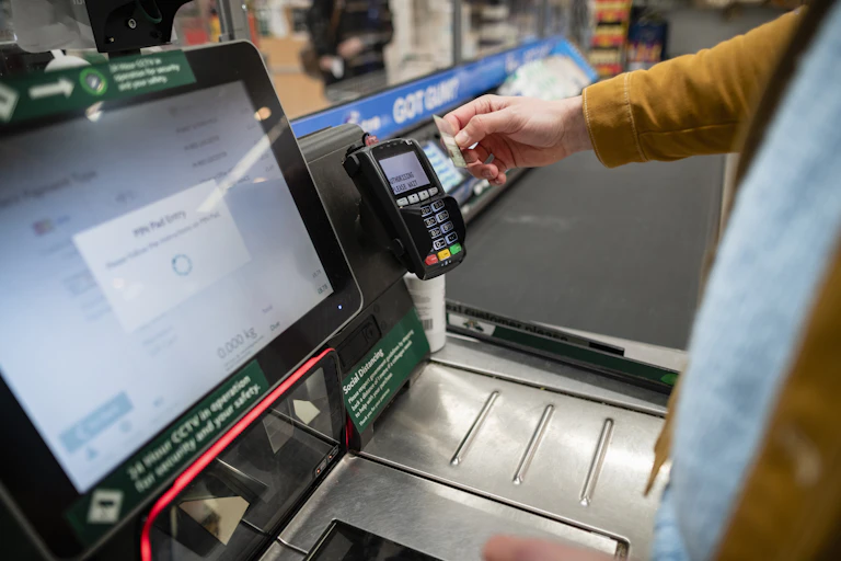 Person paying at supermarket self-checkout