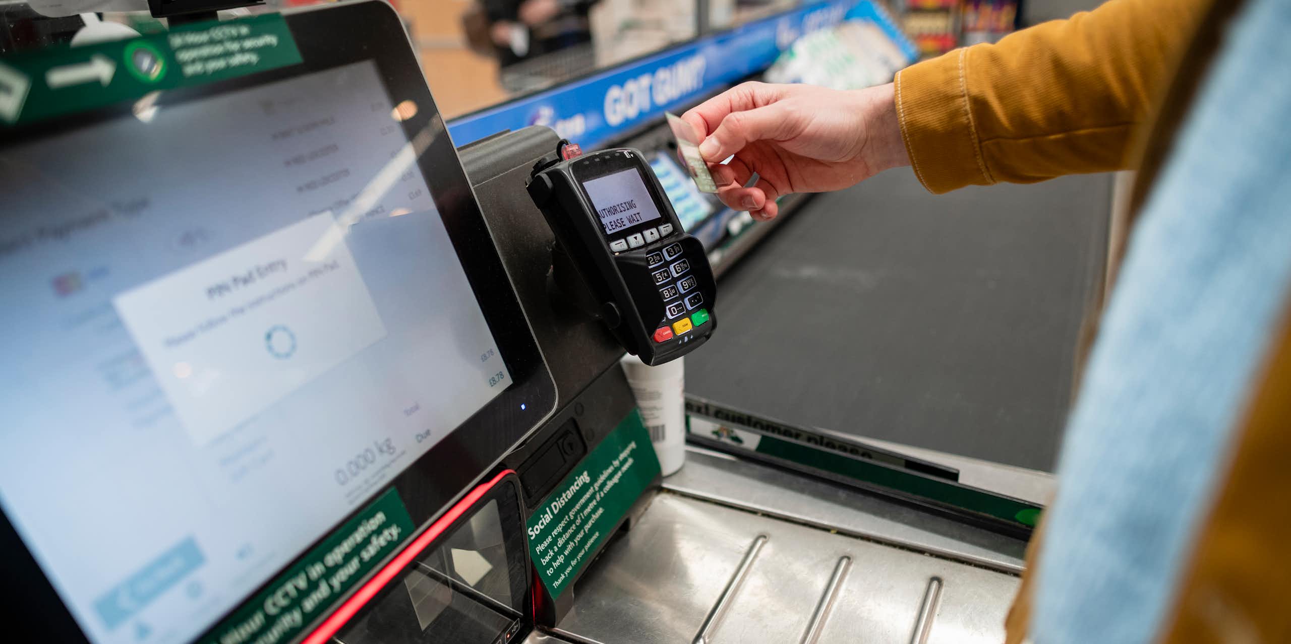Person paying at supermarket self-checkout