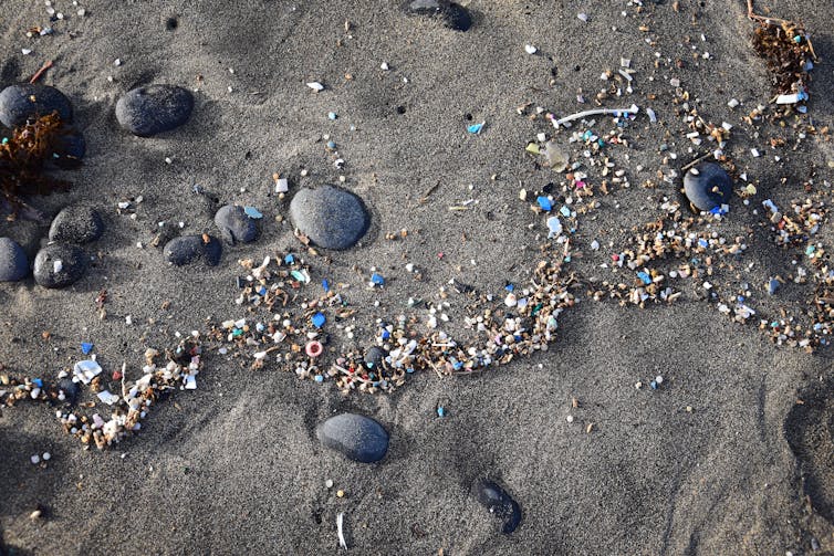 Small bits of plastics on a sandy beach