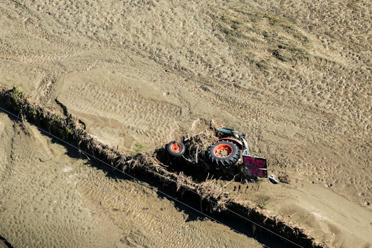 An upturned tractor in a flooded field