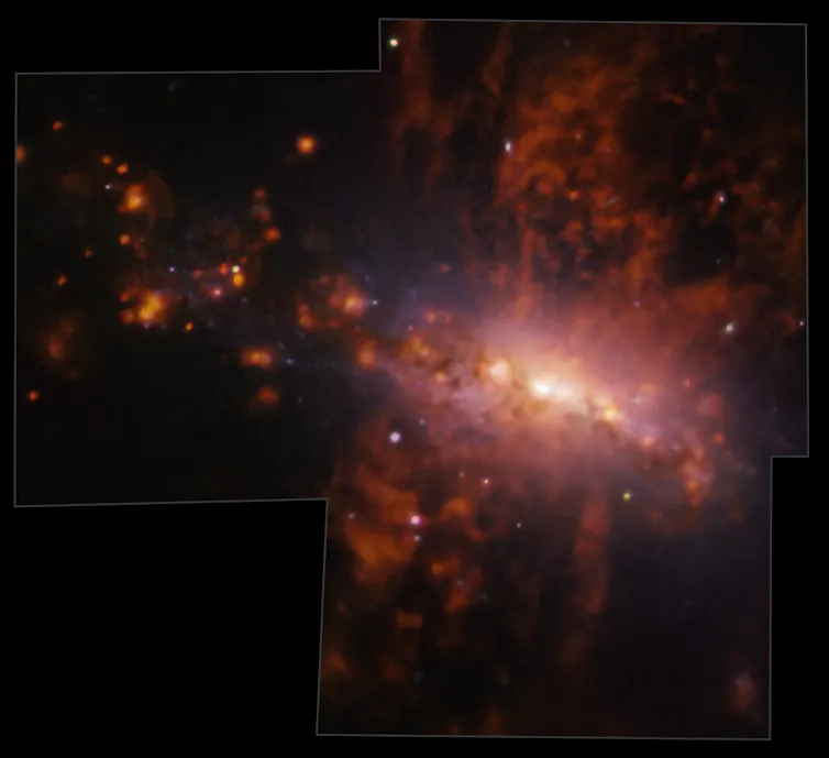 A glowing nebula in orange and peach hues on a dark background.
