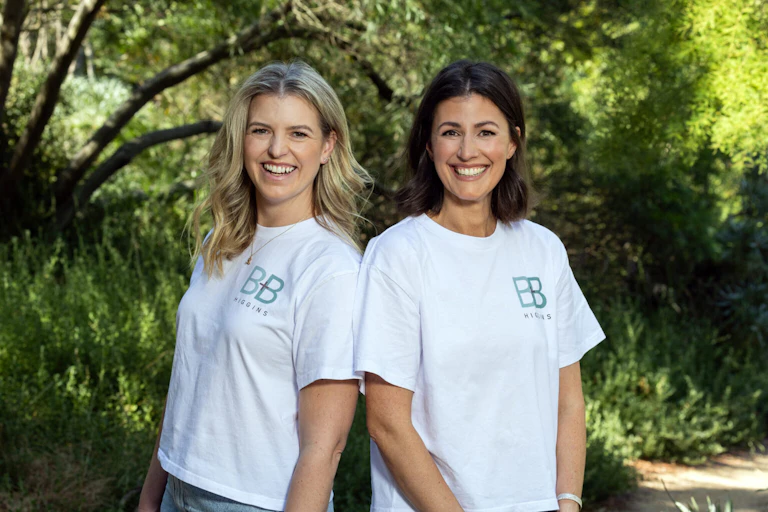Lucy Bradlow and Bronwen Bock standing back to back in a garden