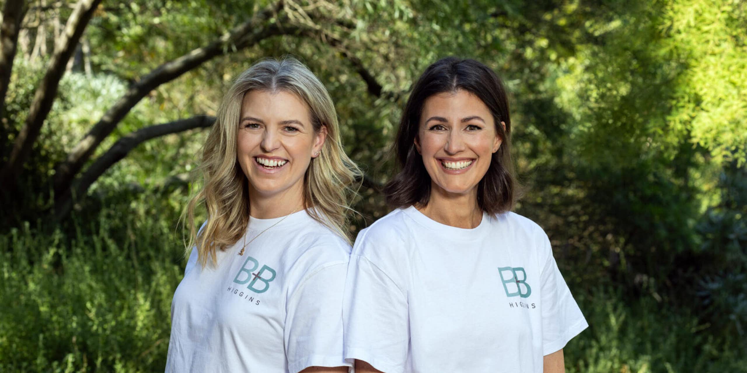 Lucy Bradlow and Bronwen Bock standing back to back in a garden