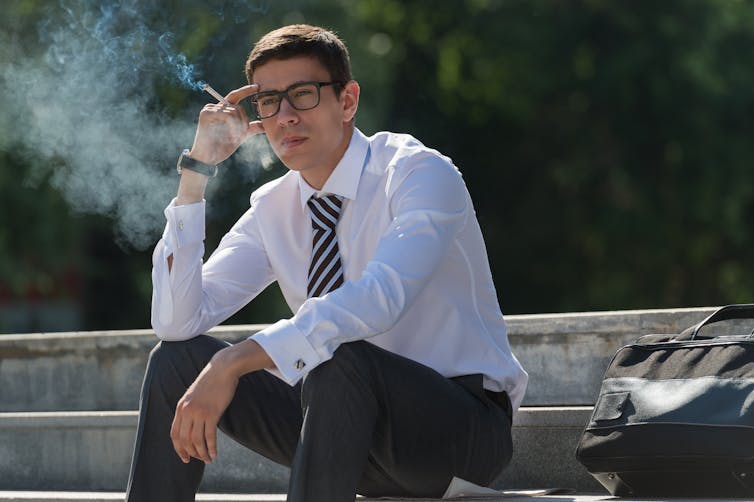 A businessman smoking a cigarette.