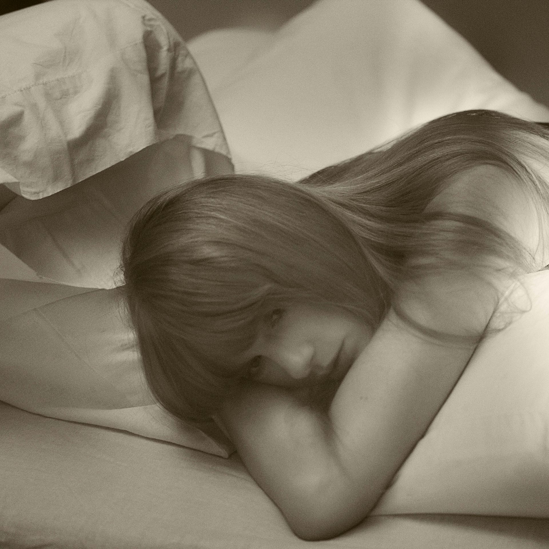 Taylor lying in a bed looking mournful.