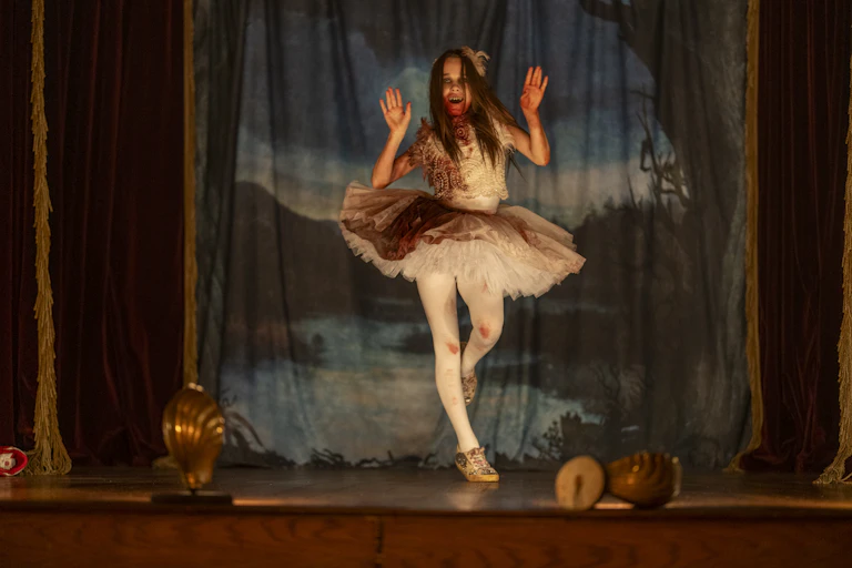 Young girl in a tutu covered in blood