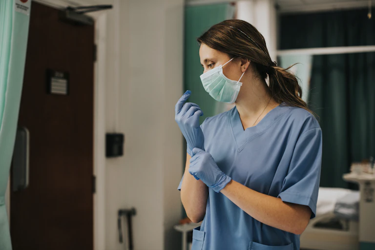 Nurse puts gloves on