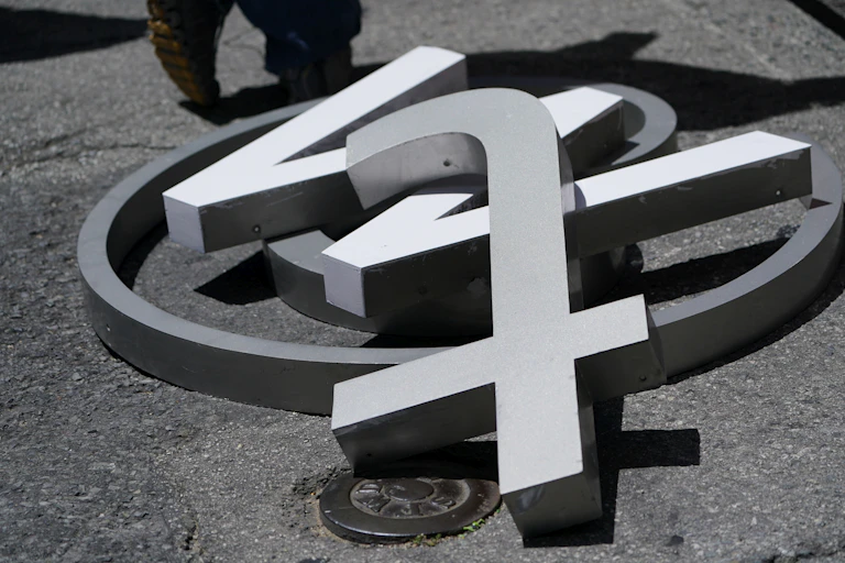 A large @ symbol, w and t lying on a street in close up.