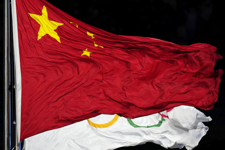 The Chinese and Olympic flags flutter together