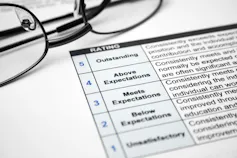 Pair of glasses and staff appraisal form sitting on a desk