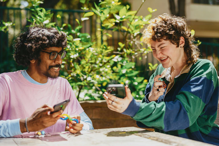 two people share a joke sitting outside in the sun