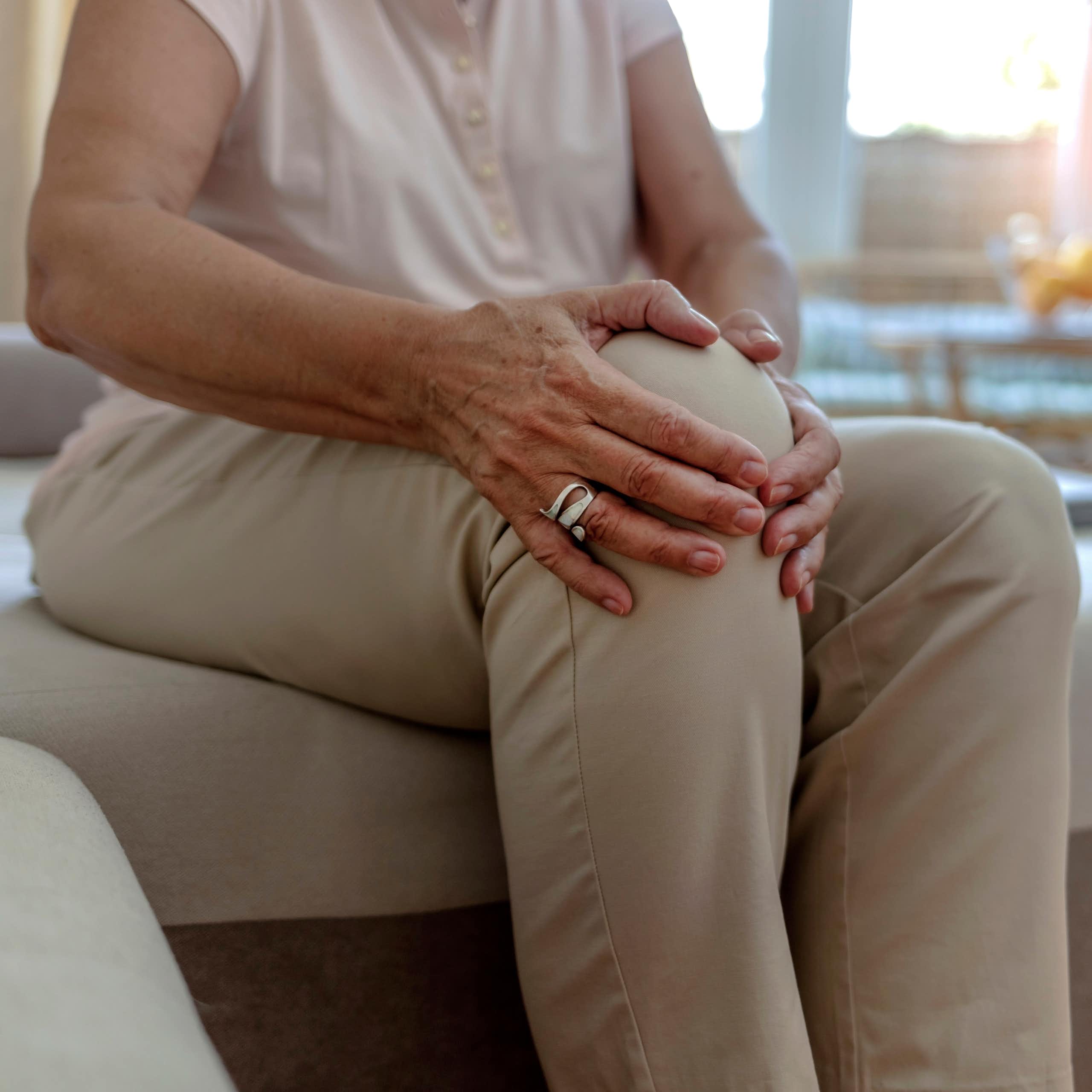 Photo d’une femme âgée se tenant le genou, visiblement douloureux.