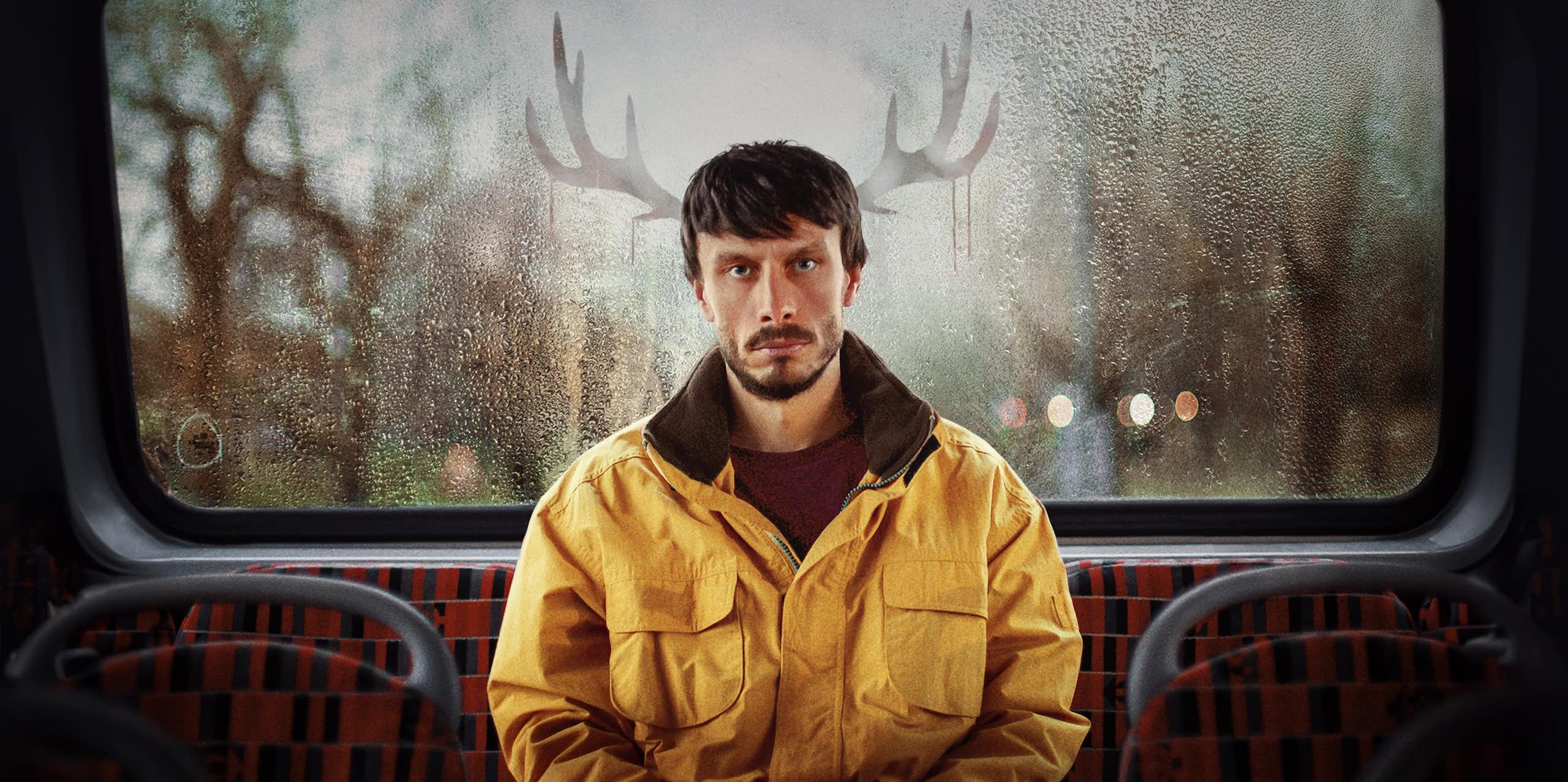 Donny on the bus with reindeer antlers drawn into the condensation in window behind him
