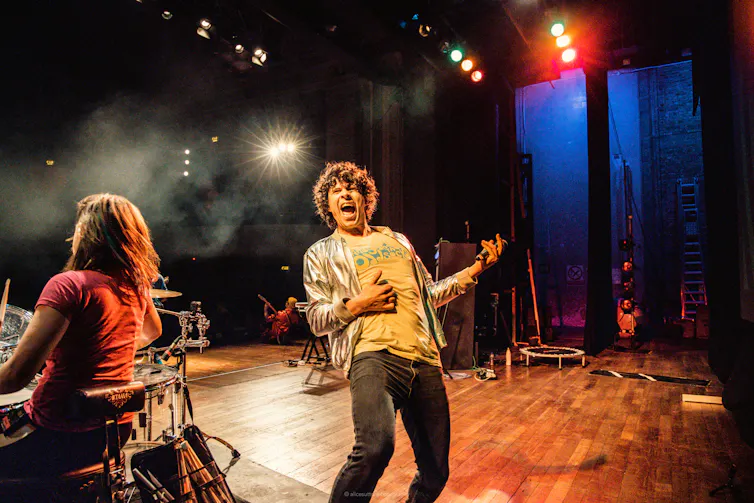 Lead singer playing air guitar on stage