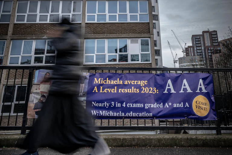 School building with banner outside reading 'Michaela average A Level results 2023: AAA