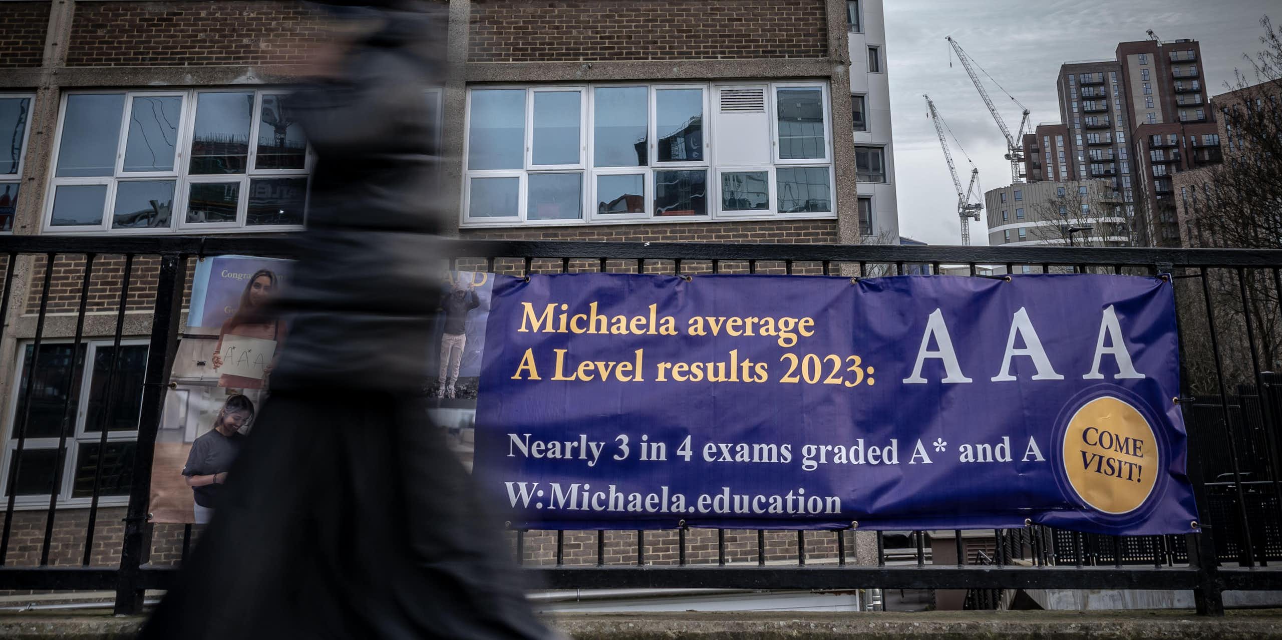 School building with banner outside reading 'Michaela average A Level results 2023: AAA