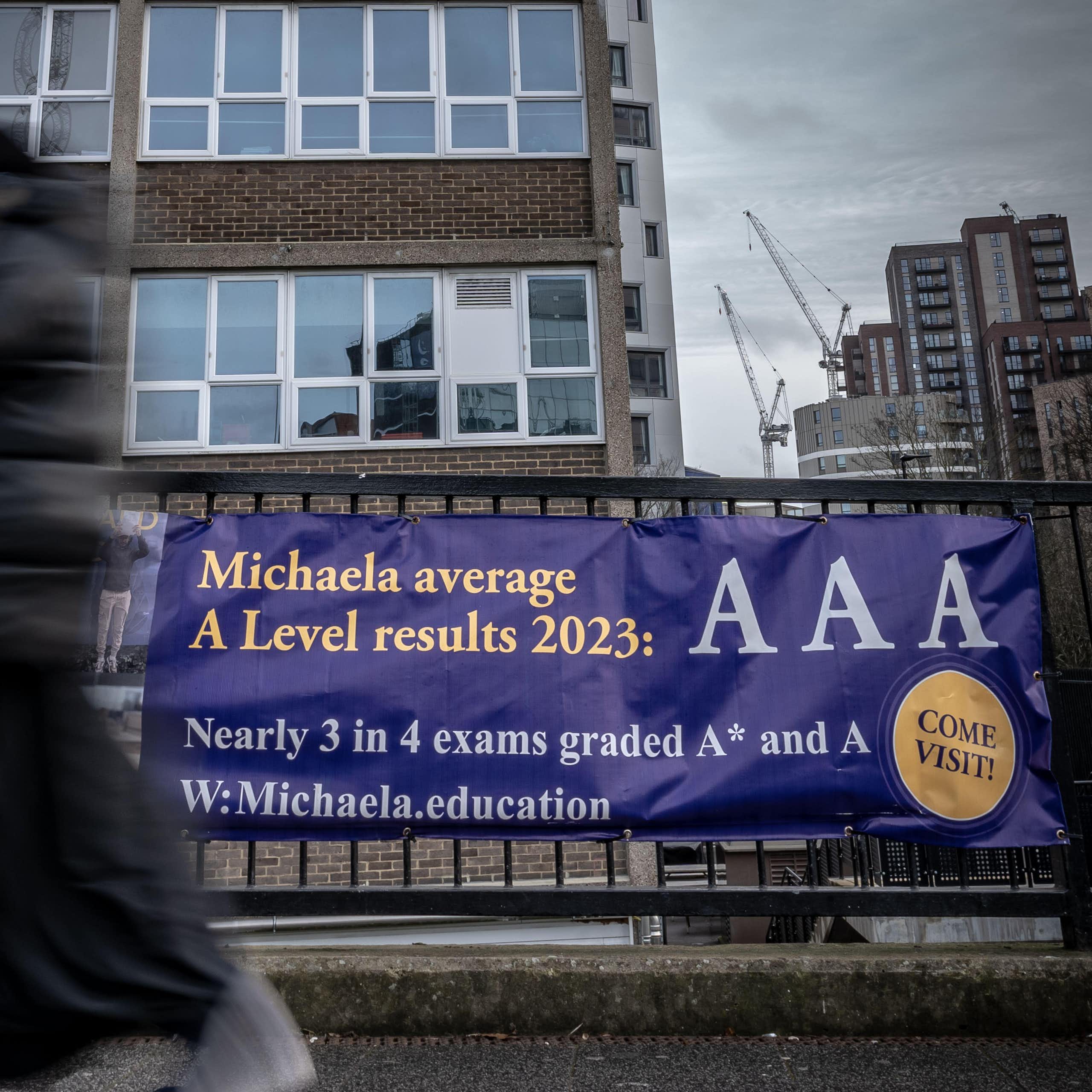 School building with banner outside reading 'Michaela average A Level results 2023: AAA
