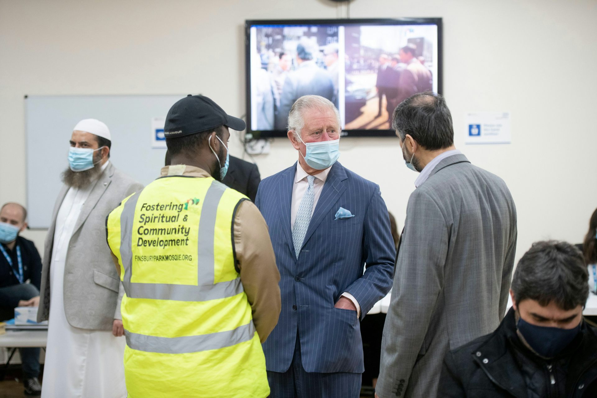 King Charles wearing a covid mask talking to two men inside Finsbury Park mosque.