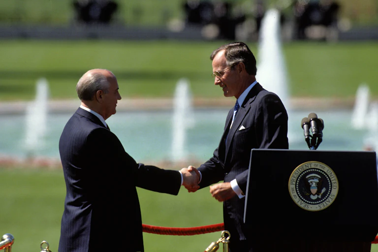 Soviet leader, Michail Gorbachev, and US president, George HW Bush, shake hands on the SHite House lawn, May 1990.