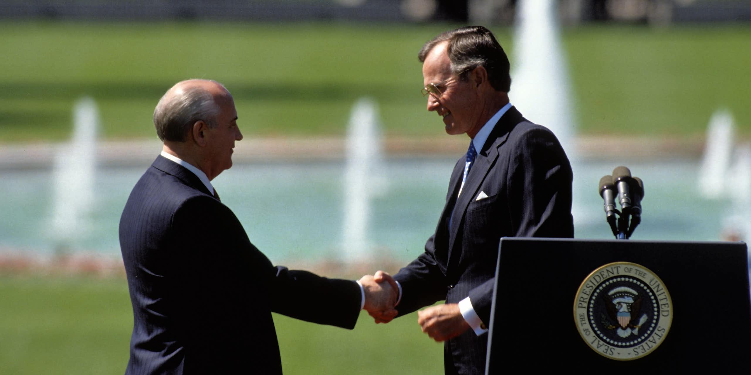 Soviet leader, Michail Gorbachev, and US president, George HW Bush, shake hands on the SHite House lawn, May 1990.