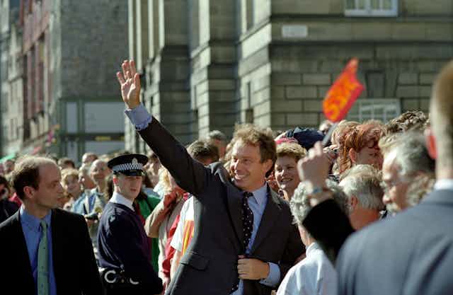 Tony Blair waving in a crowd of supporters. 