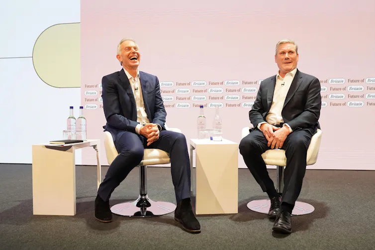 Tony Blair and Keir Starmer siting on a stage.