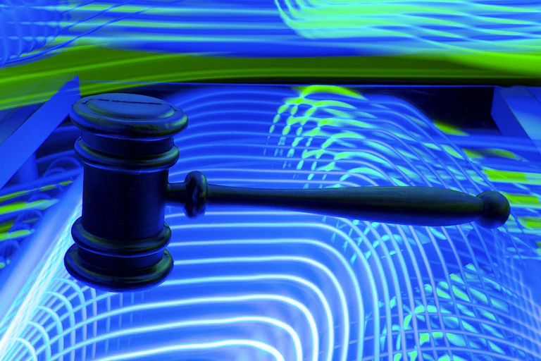 A judge's gavel on a background of neon lights.