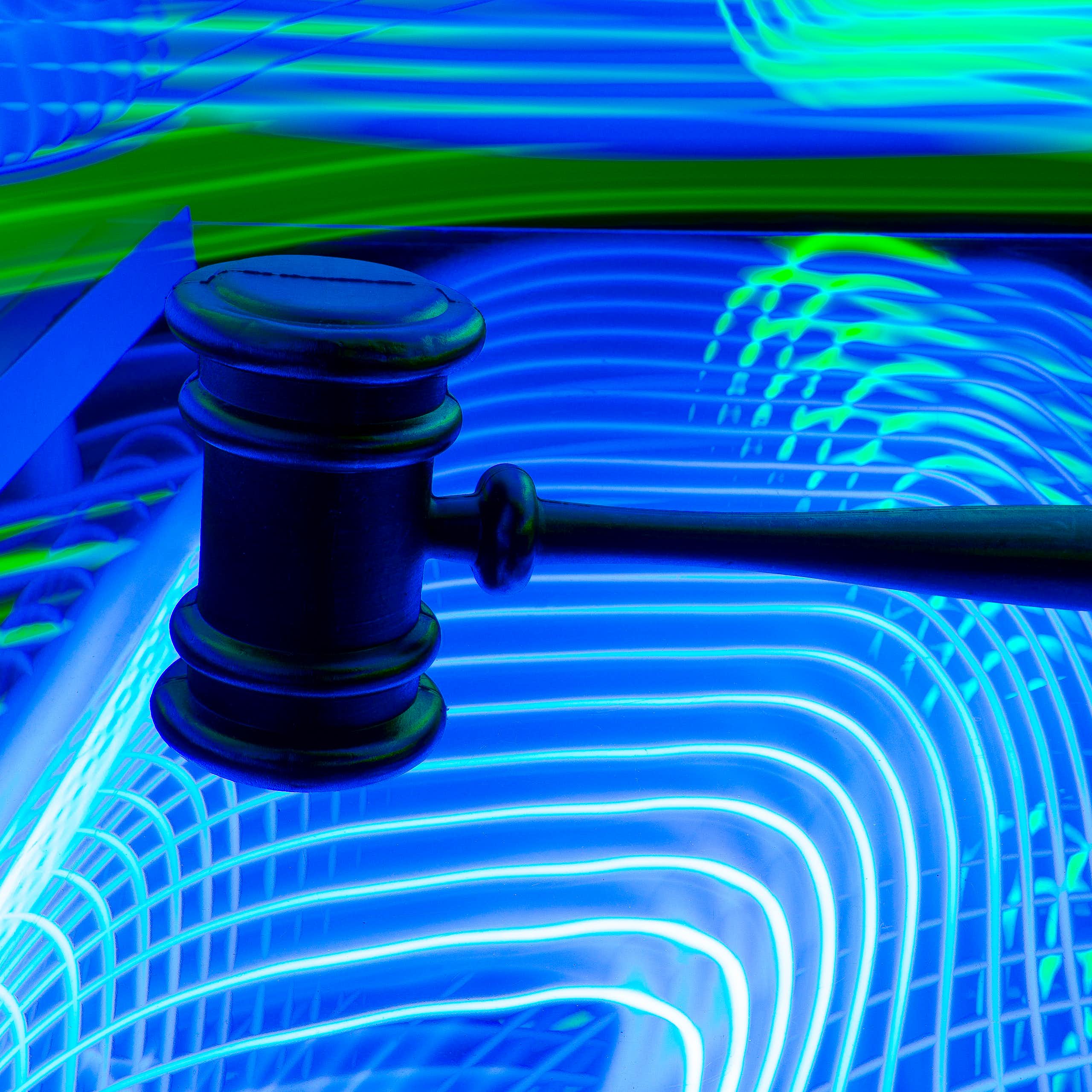 A judge's gavel on a background of neon lights.