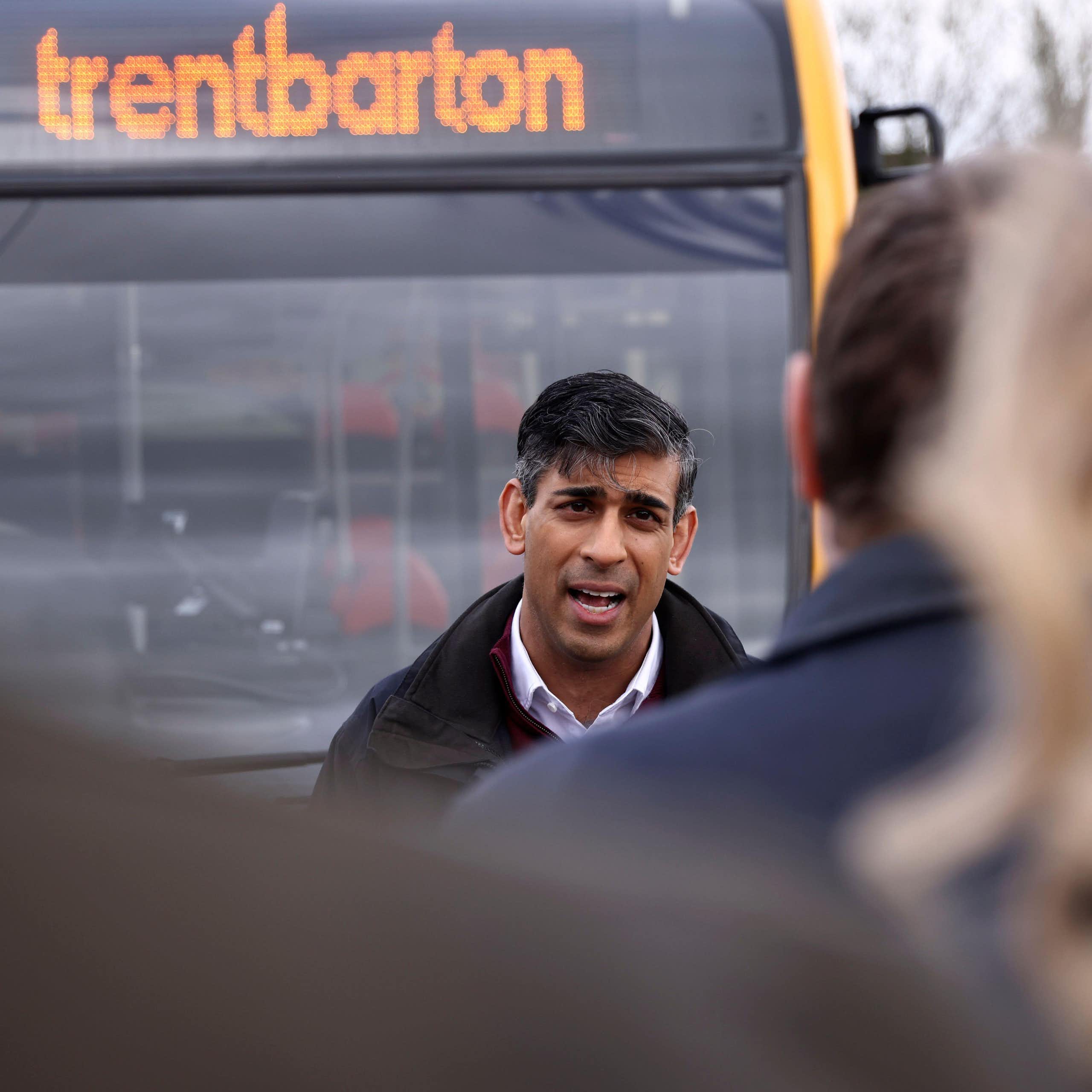 Rishi Sunak talking to a crowd of people standing in front of a bus with the destination sign reading 'trentbarton'