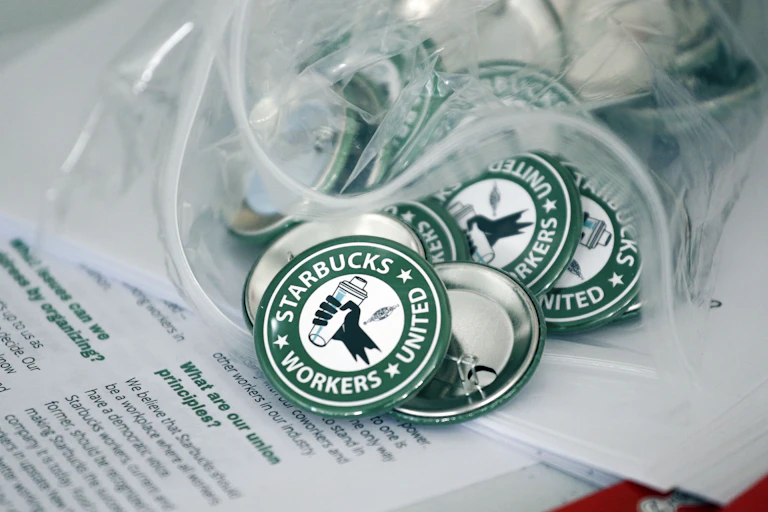 A pile of green and white Starbucks Workers United buttons