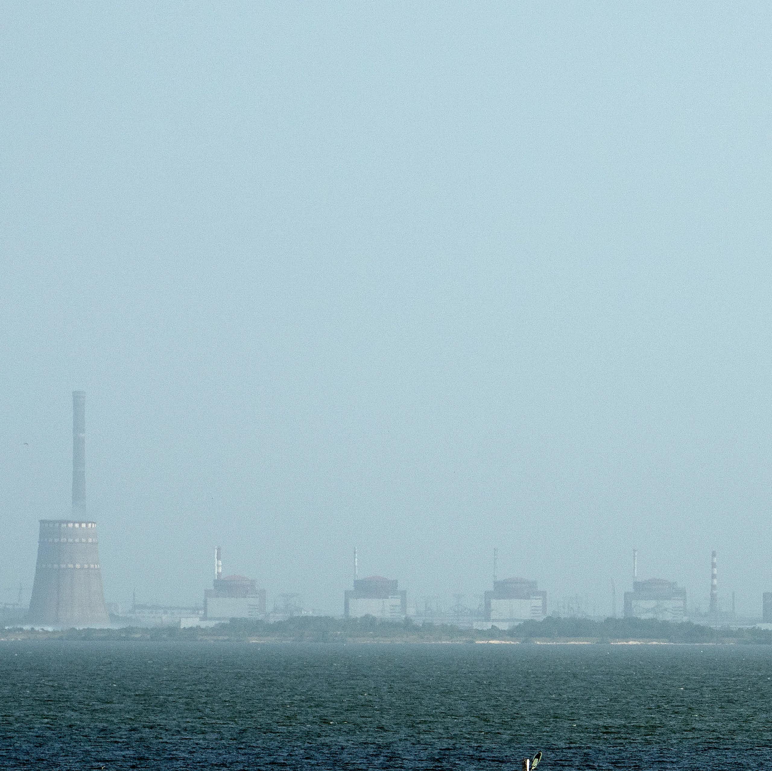 A power plant is seen across a river.