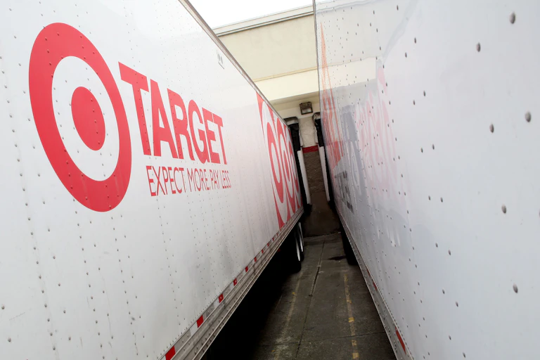 Two tractor-trailer trucks parked at a loading dock.