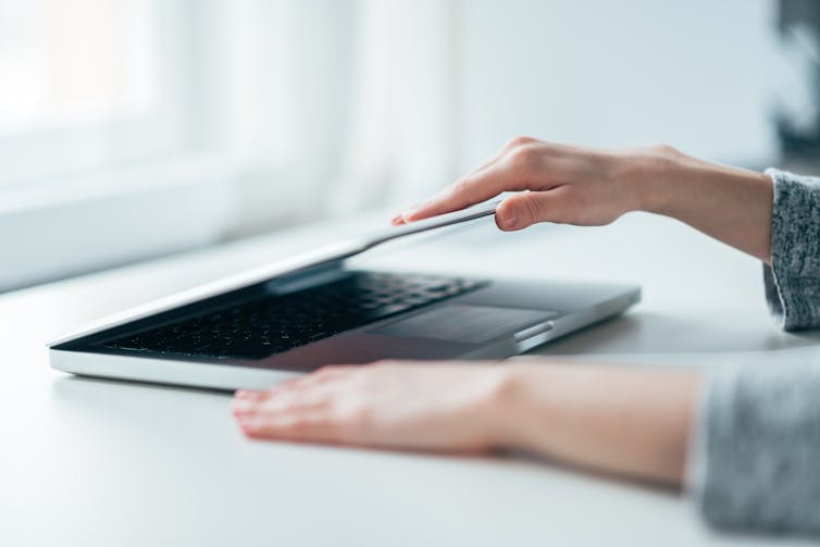 Hands closing laptop