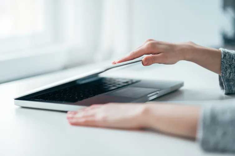 Hands closing laptop
