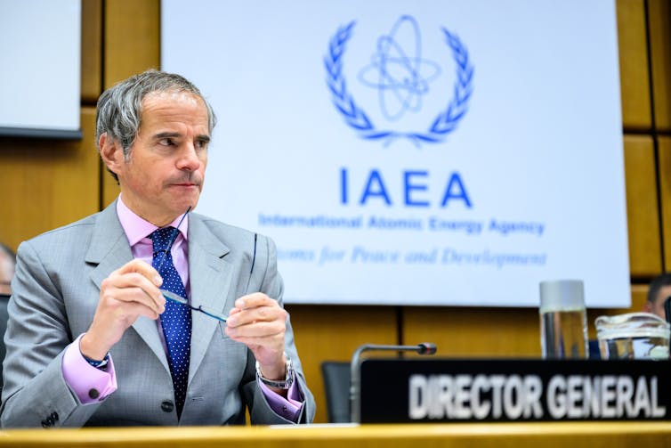 Director General of the International Atomic Energy Agency Rafael Mariano Grossi , at his desk during an IAEA meeting.