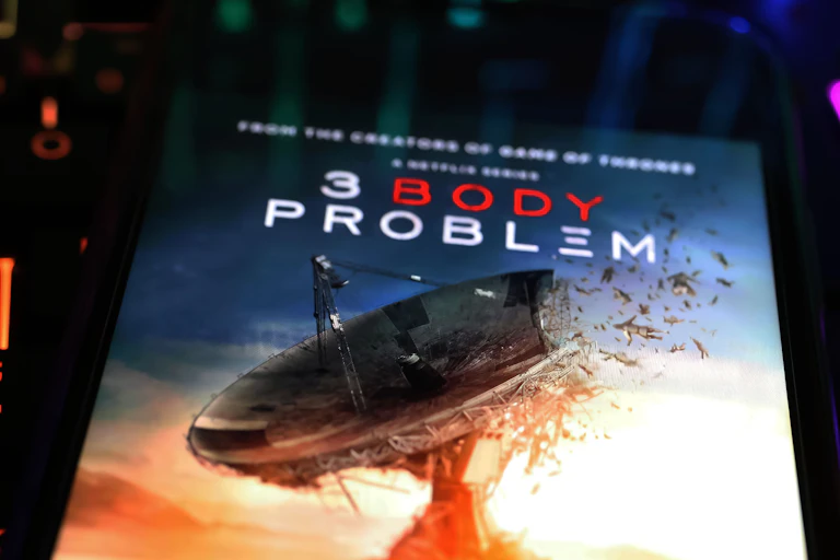 promotional poster showing a disintegrating satellite dish and the text "3 Body Problem"