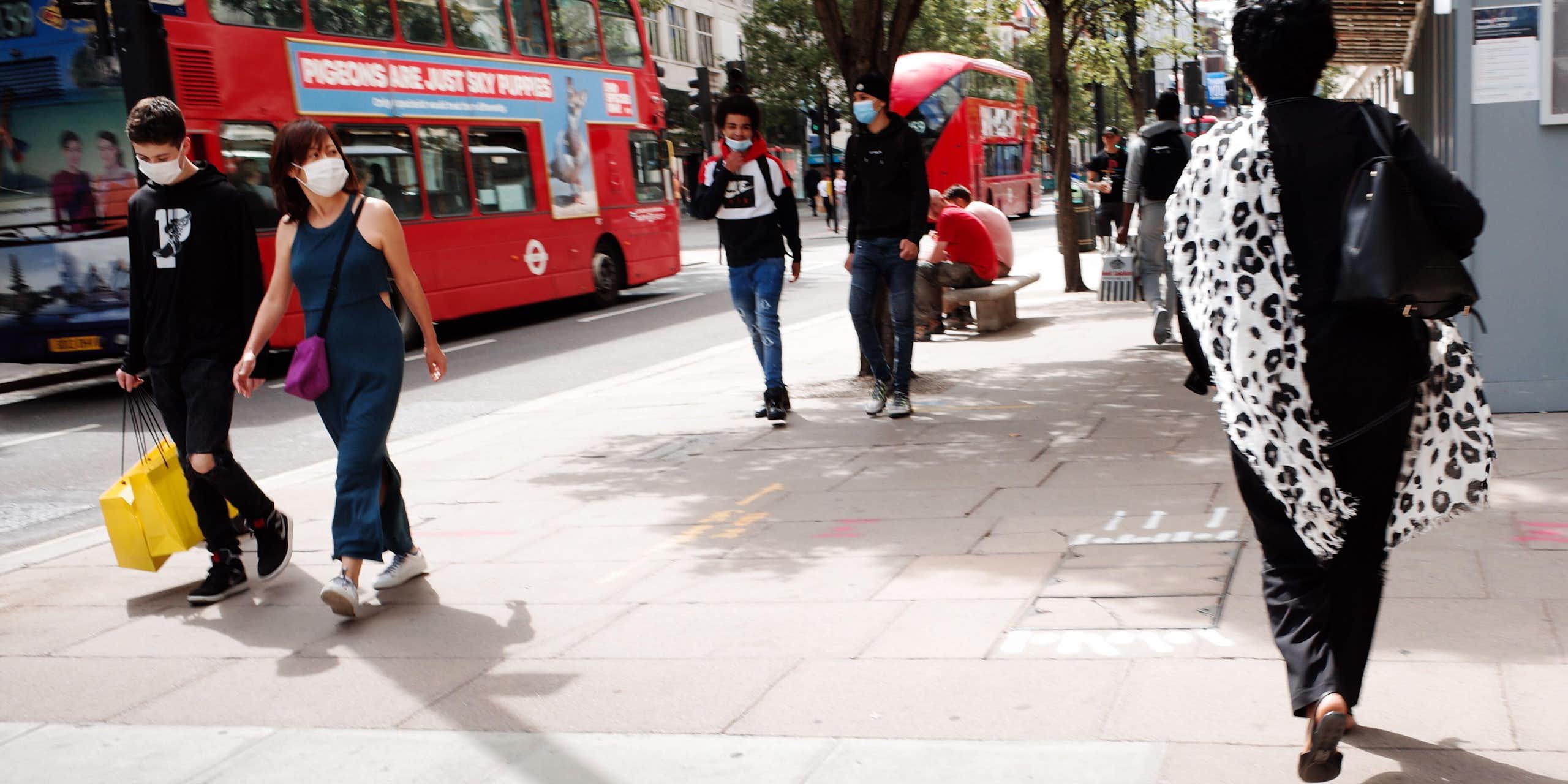 People walk on a shopping street in London.