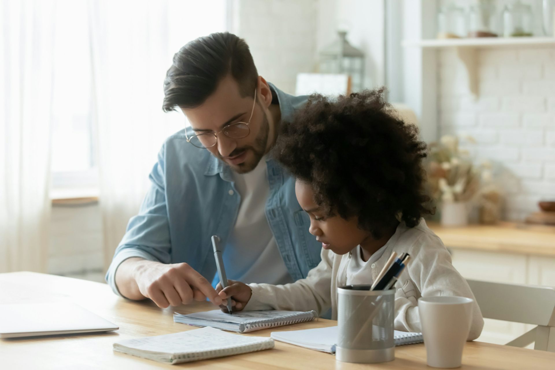 Père et sa fille faisant les devoirs scolaires du jour