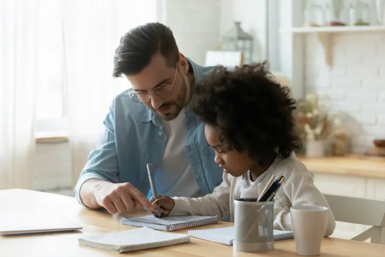 Père et sa fille faisant les devoirs scolaires du jour