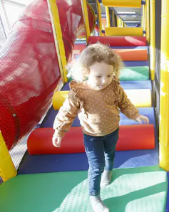 A child runnning on a play structure.